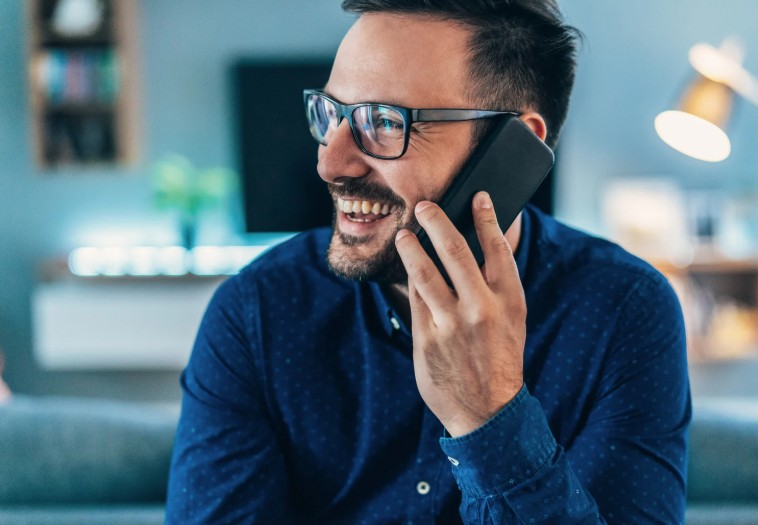 Erhvervsmand i samtale over telefonen-personlig kontakt og god dialog i samarbejdet.