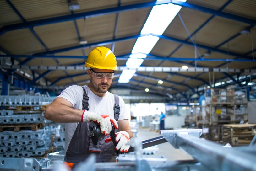 Montagemedarbejder i gang med montering af metaldele i industriproduktion.